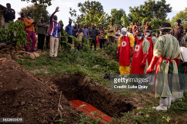 Prayer is read during a Safe and Dignified Burial of an Ebola victim on October 11, 2022 in Mubende, Uganda. Emergency response teams, isolation...