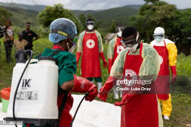 Ugandan Red Cross workers put on PPE prior to a Safe and Dignified Burial on October 11, 2022 in Mubende, Uganda. Emergency response teams, isolation...