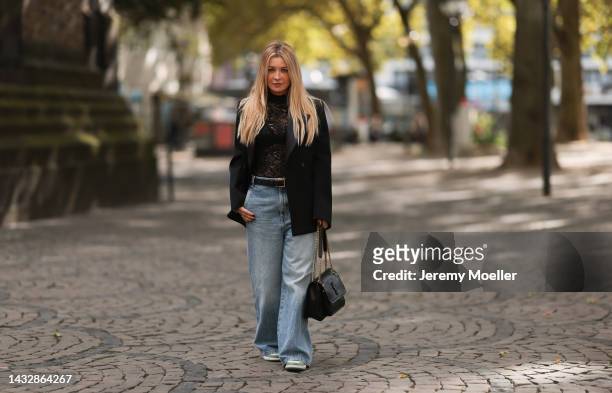 Tanja Comba is seen wearing black laced top from Dior, blue denim oversize wide leg pants from Khaite, black oversized Bottega Veneta blazer jacket,...
