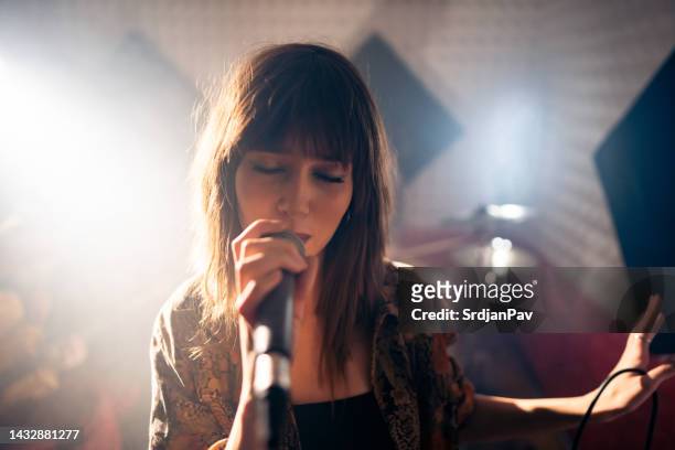 young woman singing, during rehearsal at the studio - white female singer stock pictures, royalty-free photos & images