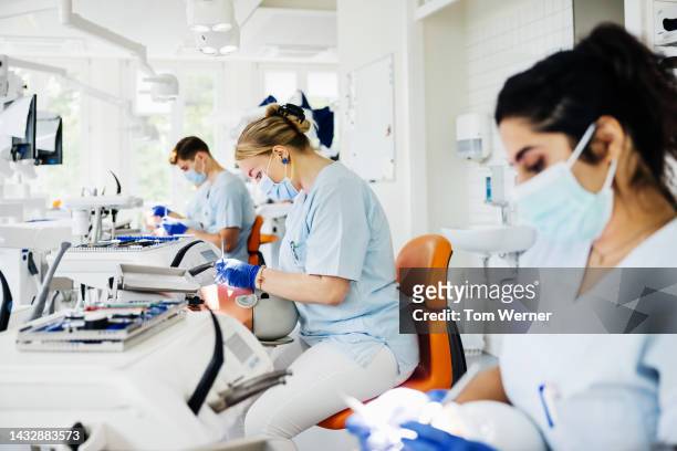 student dentists practicing on mechanical dummies in lab - germany womens training session stock pictures, royalty-free photos & images