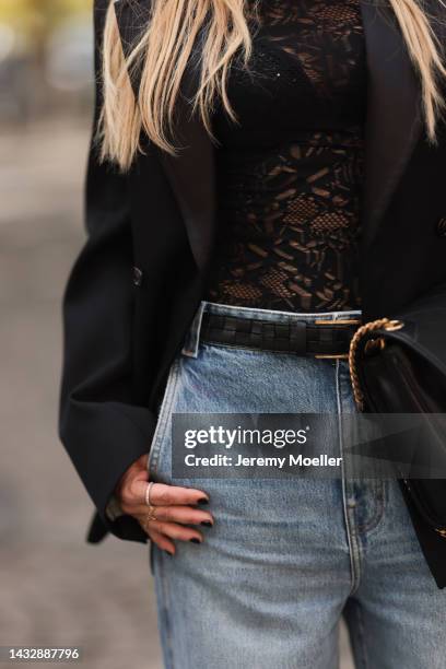 Tanja Comba is seen wearing black laced top from Dior, blue denim oversize wide leg pants from Khaite, black oversized Bottega Veneta blazer jacket...