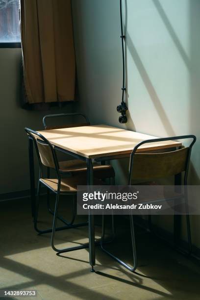 table and chairs inside a hotel room or hostel. an empty college dorm room, students on vacation. lack of visitors due to the global crisis. minimalistic interior in the hotel room. simple life, economy. - minimalist bedroom desk stock pictures, royalty-free photos & images