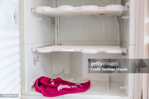 defrosting a domestic freezer - gefrierschrank stock-fotos und bilder