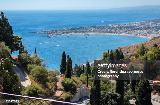 spectacular view of the blue waters of the ionic sea, the naxos coastline and the seaside resort of giardini naxos, taormina, sicily, italy - naxos sicily 個照片及圖片檔