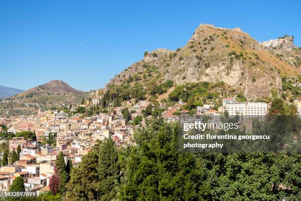 spectacular view of taormina with the castelmola, a norman castle, and the santuario madonna della roca, sicily, italy - castelmola stock-fotos und bilder