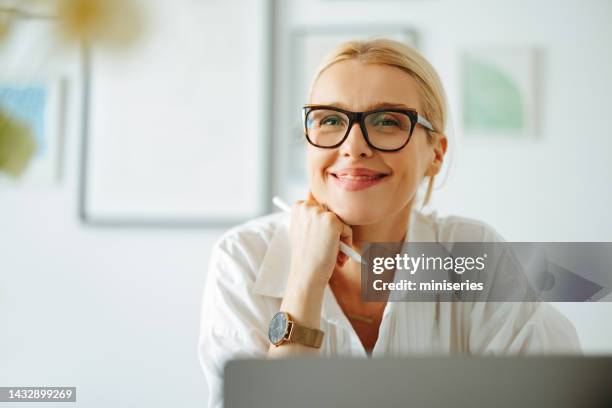 ritratto di donna d'affari sorridente che lavora su un computer portatile - blonde glasses foto e immagini stock