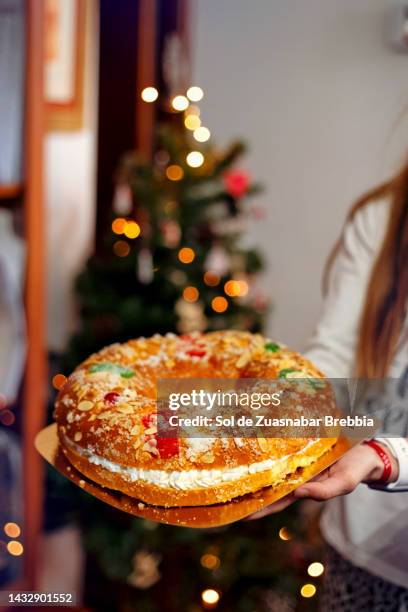 close-up of hands holding a roscón de reyes - rosca de reyes stock pictures, royalty-free photos & images