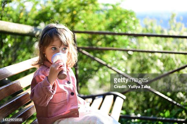 kleines entzückendes süßes babymädchen 2 jahre alt, das schokoladenmilchshake trinkt. san marino, italien - 2 3 years stock-fotos und bilder