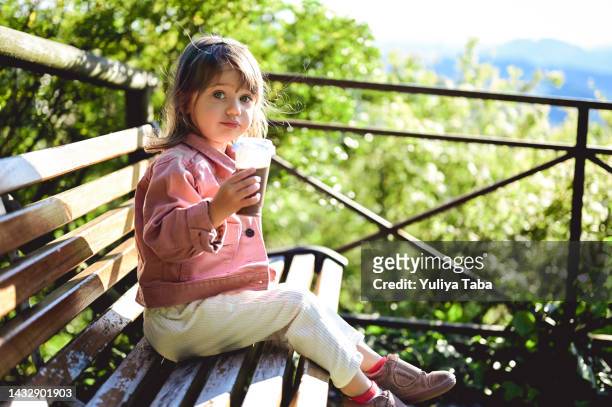 piccola adorabile bambina carina di 2 anni che beve frullato di latte al cioccolato. san marino, italia - 2 3 years foto e immagini stock