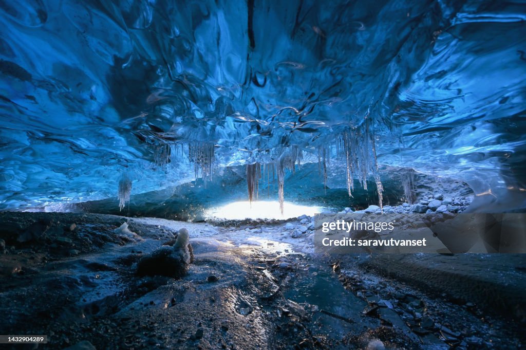 Photographer standing underground inside of a glacier,