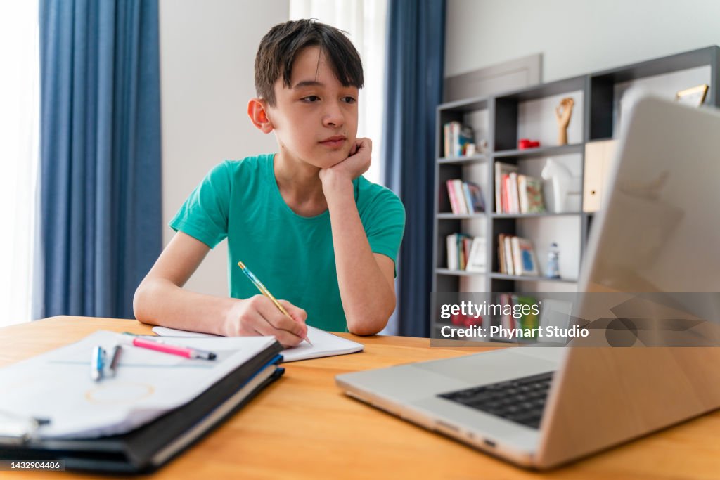 Ragazzo adolescente che ha una lezione scolastica online a casa
