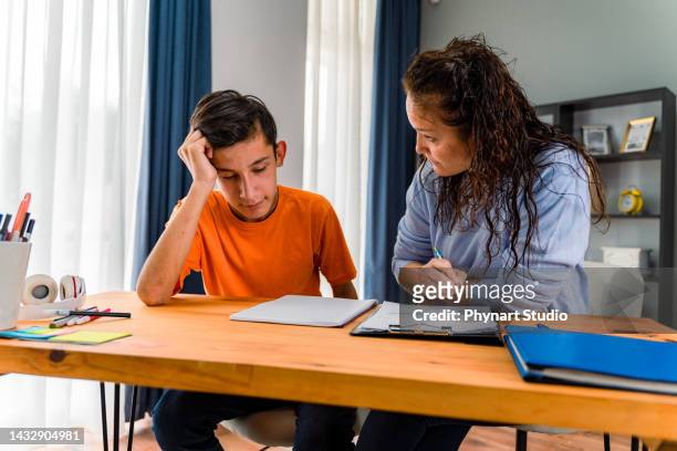 smiling female tutor helping young student doing homework. tutorial and educational concept - teaching assistant stock pictures, royalty-free photos & images