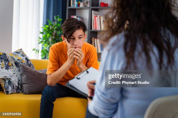 female psychologist counseling teenage boy in office - adolescence 個照片及圖片檔