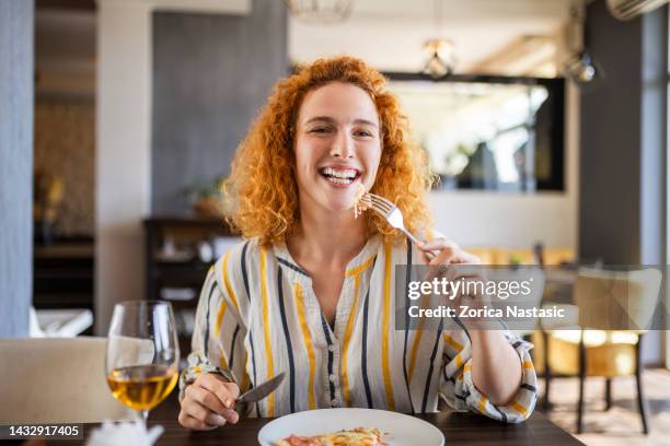 donna sorridente che ha pizza e vino guardando la macchina fotografica - lunch cheese foto e immagini stock