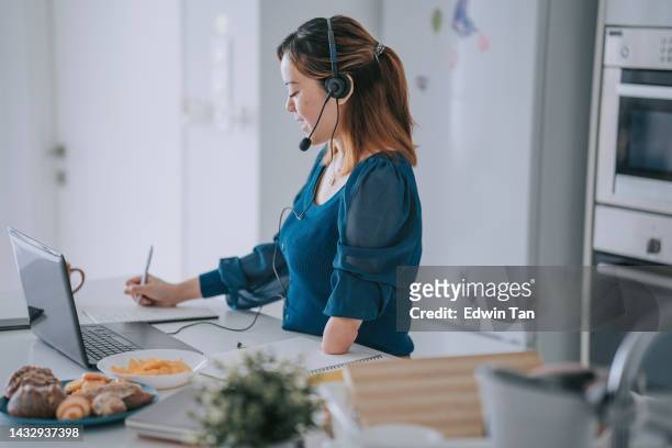 chinese woman with disability deformed arm work from home video call at kitchen counter business meeting virtual event - of deformed people stock pictures, royalty-free photos & images
