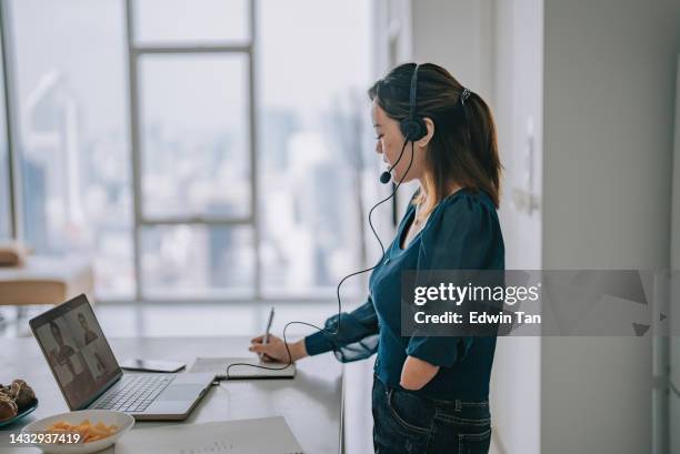 chinese woman with disability deformed arm work from home video call at kitchen counter business meeting virtual event - amputee women stockfoto's en -beelden