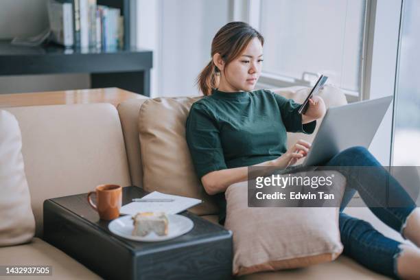 asian chinese woman with disability deformed arm checking text messages at home sitting on sofa bed - of deformed people stock pictures, royalty-free photos & images
