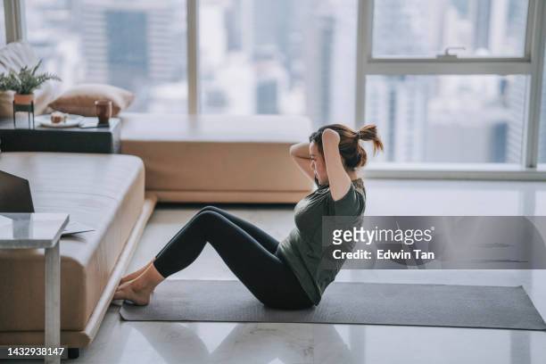 chinese woman with disability deformed arm sit up home workout watching online class guidance with laptop - sit ups stockfoto's en -beelden