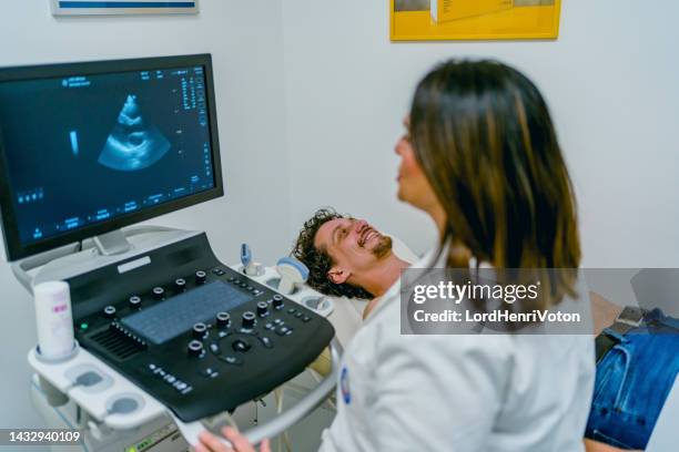 mann mit einer ultraschalluntersuchung des herzens - echokardiogramm stock-fotos und bilder