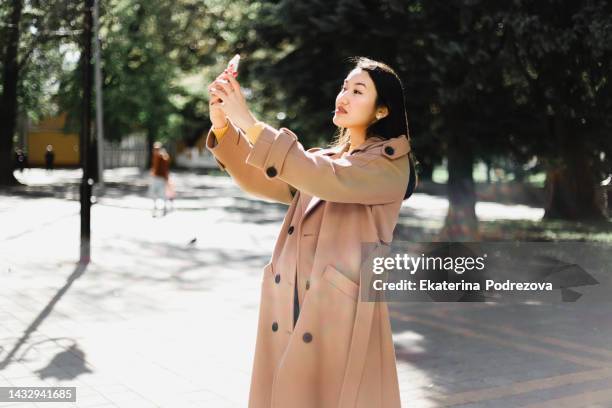 the girl is interacting with a mobile phone - rim light portrait stock pictures, royalty-free photos & images