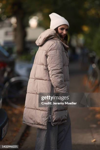 Anna Wolfers wearing a cream knit hat, cream turtleneck sweater, beige winter coat, plaid brown trousers on October 06, 2022 in Hamburg, Germany.