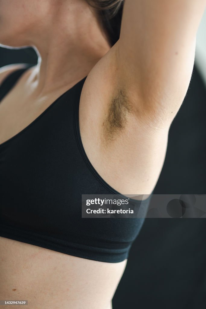 Woman showing her hair under armpit