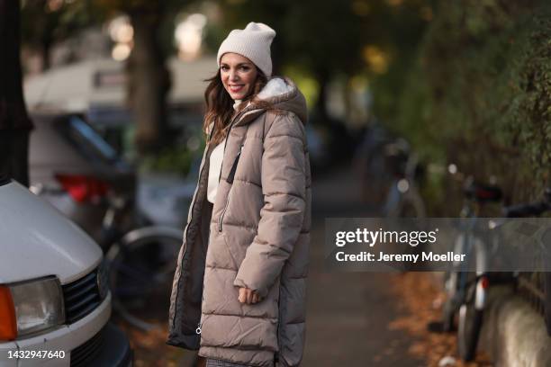 Anna Wolfers wearing a cream knit hat, cream turtleneck sweater, beige winter coat, plaid brown trousers on October 06, 2022 in Hamburg, Germany.