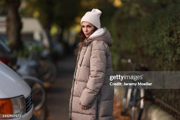 Anna Wolfers wearing a cream knit hat, cream turtleneck sweater, beige winter coat, plaid brown trousers on October 06, 2022 in Hamburg, Germany.