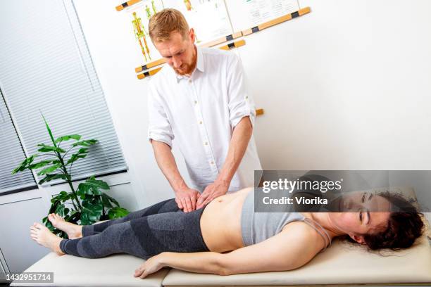 osteopata che guarisce una giovane donna - zona inguinale foto e immagini stock