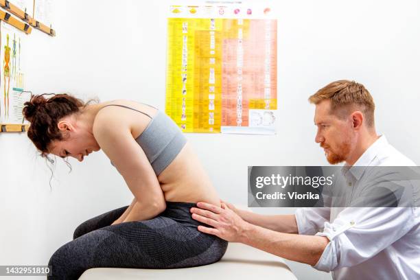 osteopath healing a young woman - lower back pain stock pictures, royalty-free photos & images