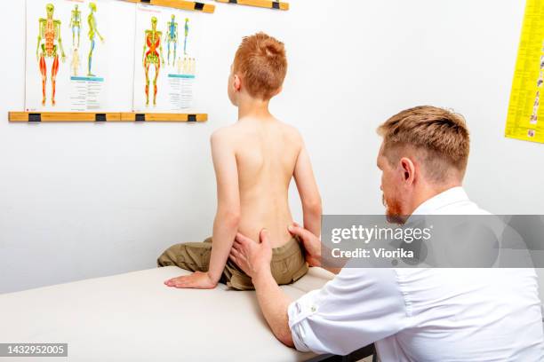 osteopath healing a young boy - medische onderzoekskamer stockfoto's en -beelden