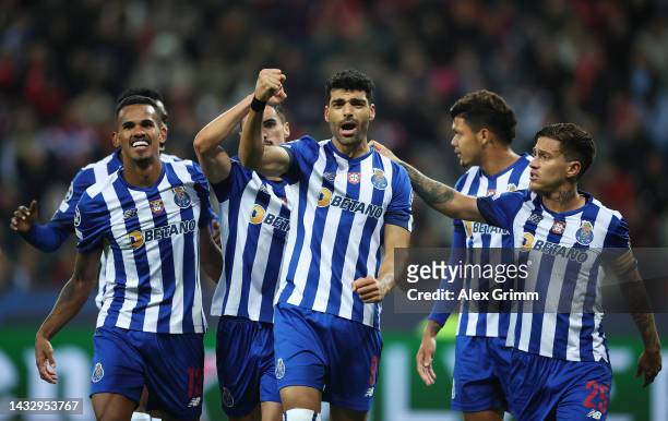 Mehdi Taremi of FC Porto celebrates with teammates after scoring their team's third goal from the penalty spot during the UEFA Champions League group...