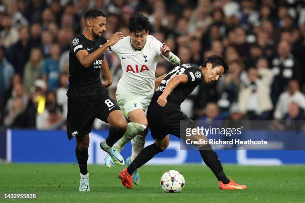 Son Heung-Min of Tottenham Hotspur is challenged by Djibril Sow and Makoto Hasebe of Eintracht Frankfurt during the UEFA Champions League group D...