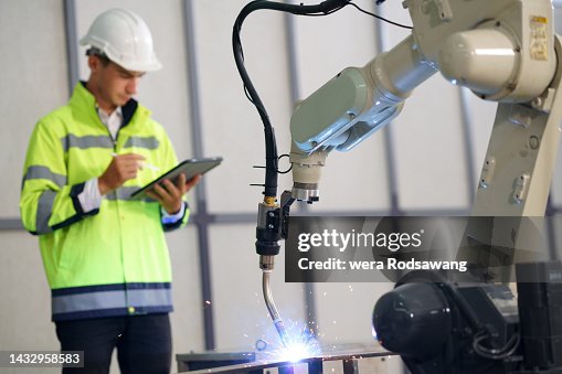 Industrial engineer testing Automatic robotic arm welding machine Industrial engineer testing Automatic robotic arm welding machine
