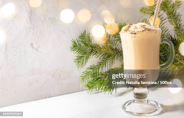 traditional christmas drink eggnog in glass,fir branches with christmas lights on white backdrop,russia - eggnog stock pictures, royalty-free photos & images