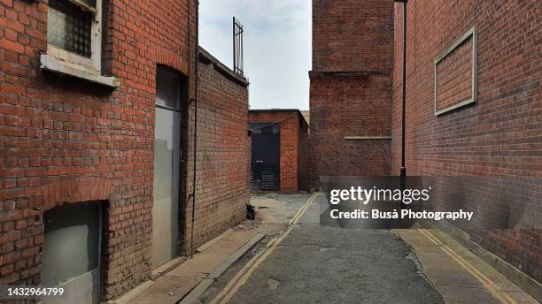 narrow back alley with industrial brick walls in london, england - old alleyway stock pictures, royalty-free photos & images
