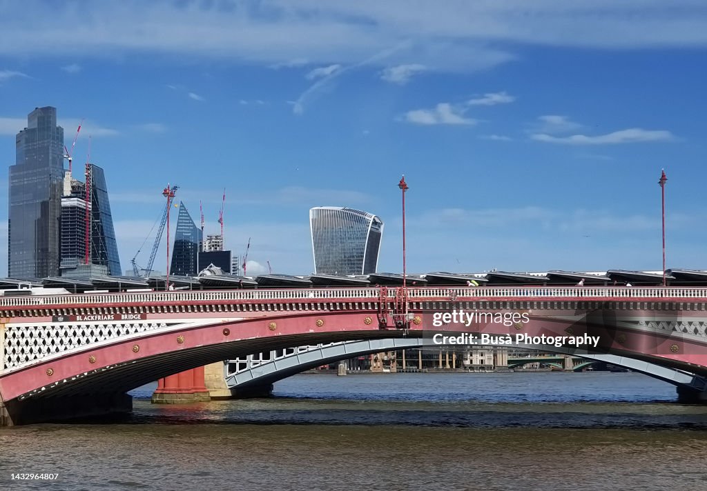 Blackfriars Bridge over the River Thames in London with highrise towers of the City of London in the background. London, England