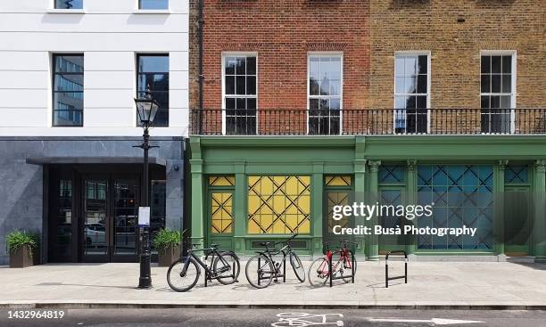 bicycles on bike racks along sidewalk in residential area of london, england - london fashion stock pictures, royalty-free photos & images