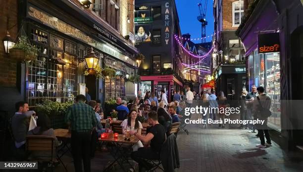 young people sitting at pub in kingly street in london's soho district, london, england - carnaby street stock pictures, royalty-free photos & images
