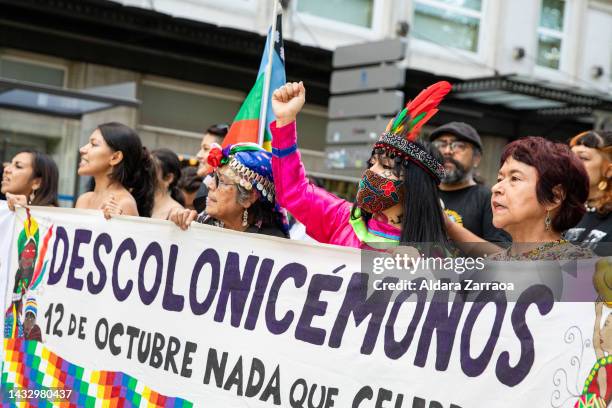 Women hold a sign that translated reads "Let's decolonize" during a demonstration against Hispanic Day on October 12, 2022 in Madrid, Spain. Spain's...