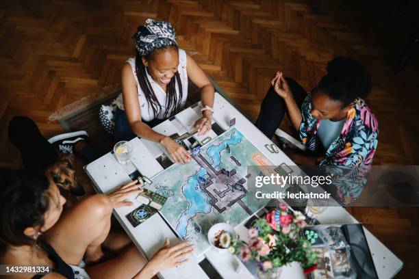gruppe von freunden, die zu hause ein brettspiel spielen - rollenspiel stock-fotos und bilder