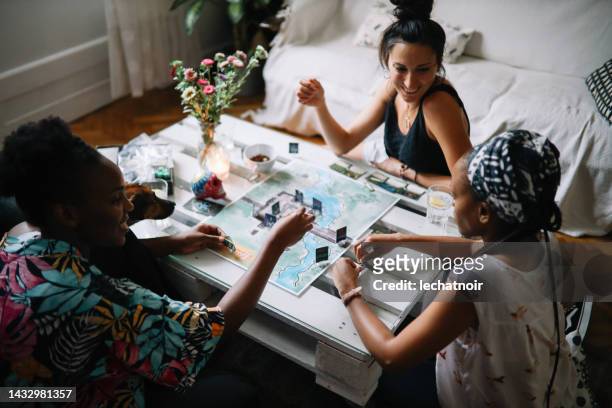 gruppo di amici che giocano a un gioco da tavolo a casa - game night foto e immagini stock