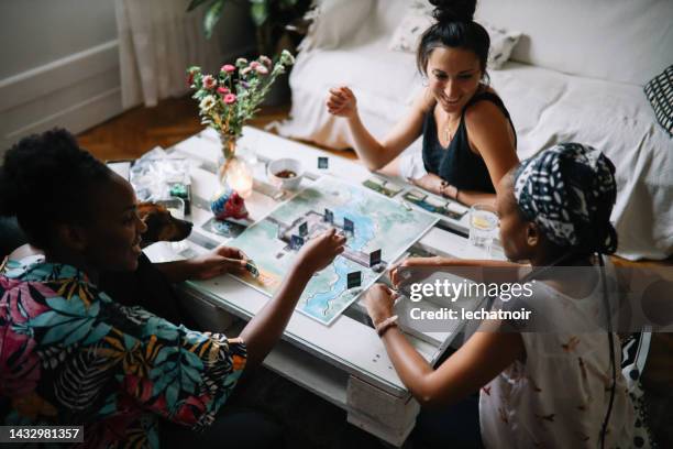group of friends playing a boardgame at home - bordspel stockfoto's en -beelden