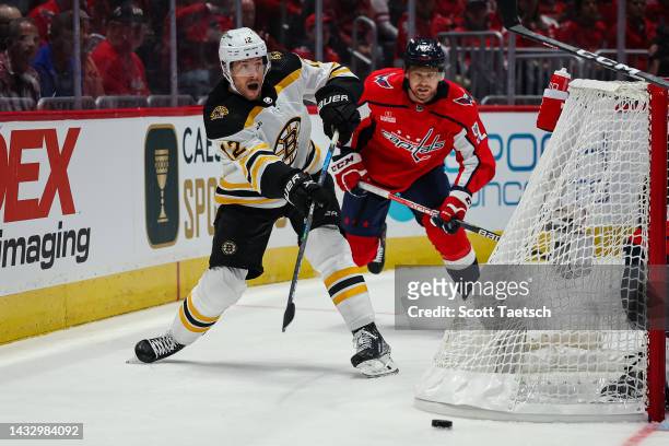Craig Smith of the Boston Bruins passes the puck in front of Evgeny Kuznetsov of the Washington Capitals during the first period of the game at...