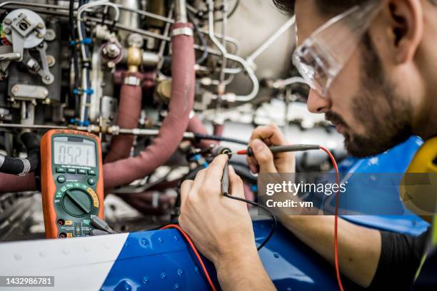aiplane mechanic checking aircraft engine with multimeter, close view on measurements - aiplane engine stock pictures, royalty-free photos & images