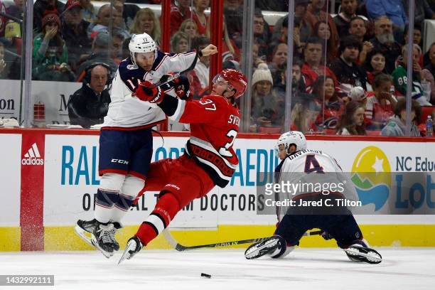 Justin Danforth of the Columbus Blue Jackets body checks Andrei Svechnikov of the Carolina Hurricanes during the second period of the game at PNC...