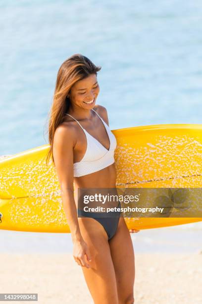 japanese surfer girl walking along beach alone with surfboard - okinawa islands stock pictures, royalty-free photos & images
