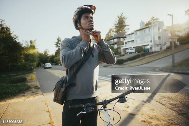 cyclist riding bike in city setting - crossbody bag 個照片及圖片檔