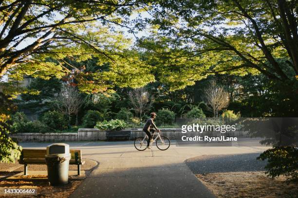 cyclist riding bike in city setting - seattle stock pictures, royalty-free photos & images